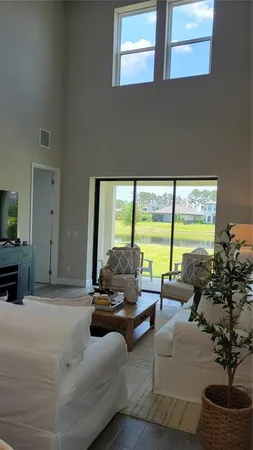 a living room with furniture and floor to ceiling windows
