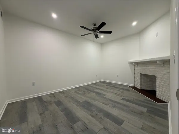 a view of empty room with wooden floor and fireplace