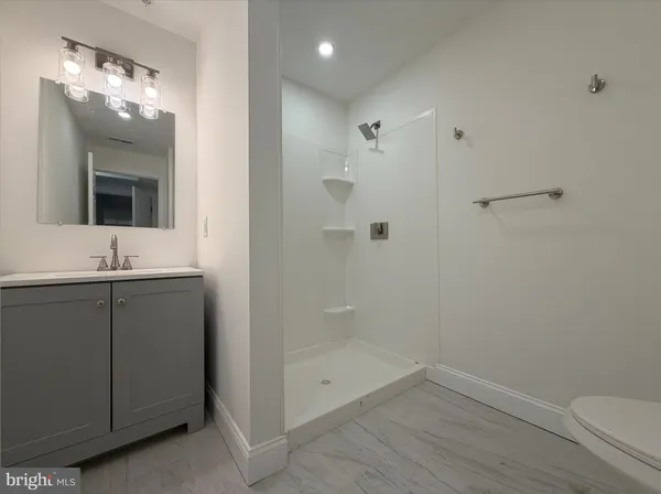 a bathroom with a shower sink vanity and mirror