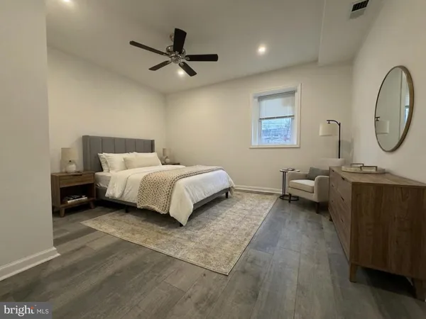 a bedroom with a bed a couch and a chandelier