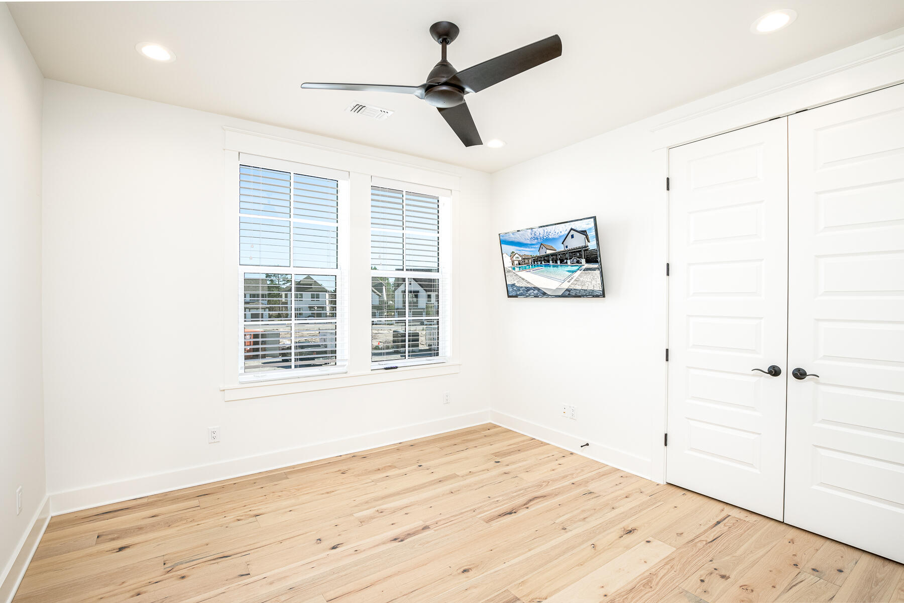 299 Ridgewalk Circle Santa Rosa Beach, FL 32459 - Photo 26 of 46 an empty room with wooden floor ceiling fan and windows