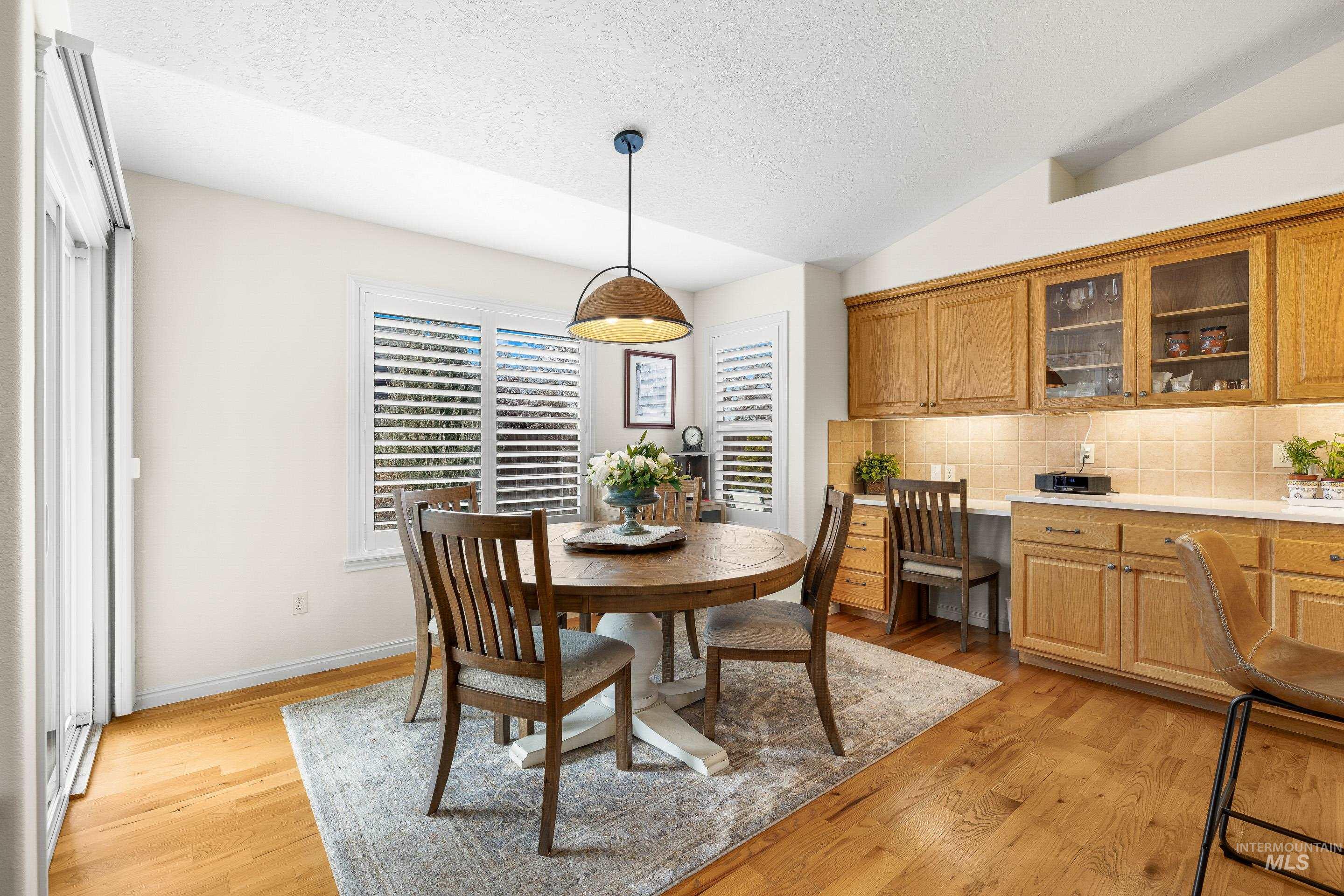 3631 North Alexis Way Meridian, ID 83646 - Photo 14 of 49 Dining area with lofted ceiling, light wood-style flooring, and a textured ceiling