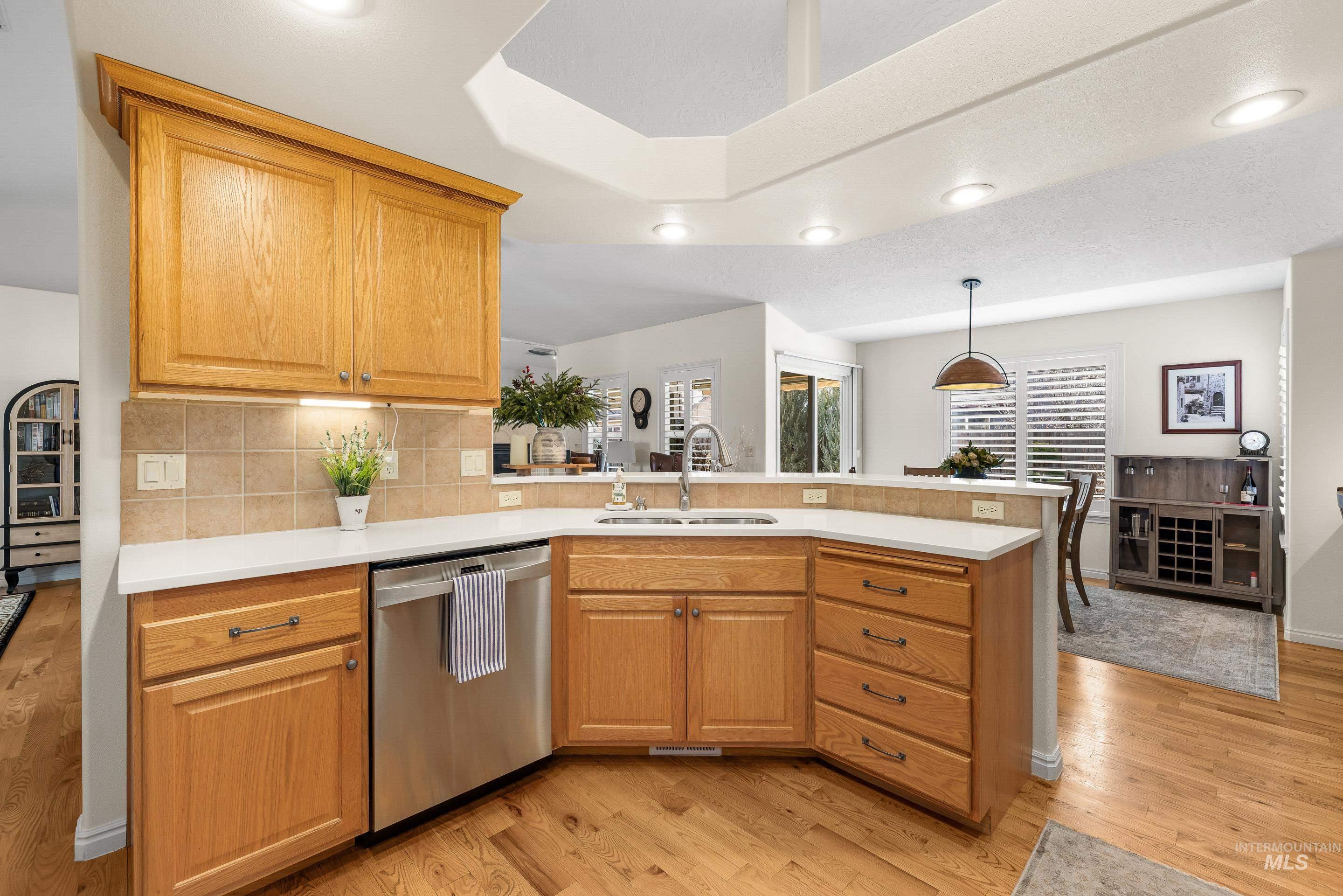 3631 North Alexis Way Meridian, ID 83646 - Photo 22 of 49 Kitchen featuring dishwasher, a peninsula, light wood-style floors, pendant lighting, and recessed lighting