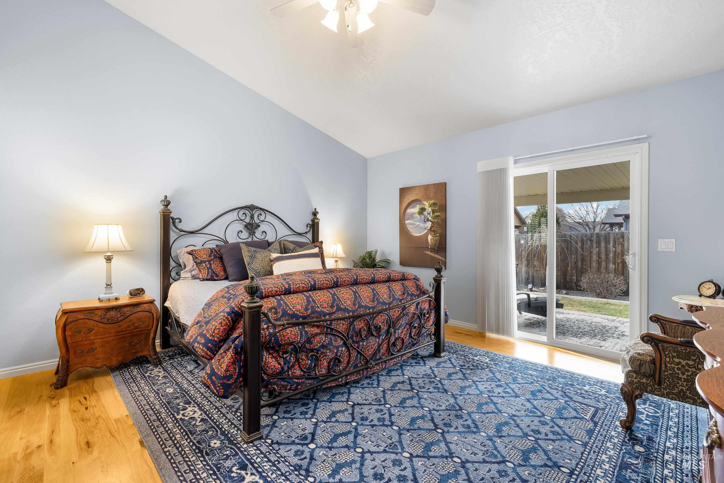 3631 North Alexis Way Meridian, ID 83646 - Photo 27 of 49 Bedroom featuring access to outside, light wood-style flooring, a ceiling fan, and vaulted ceiling