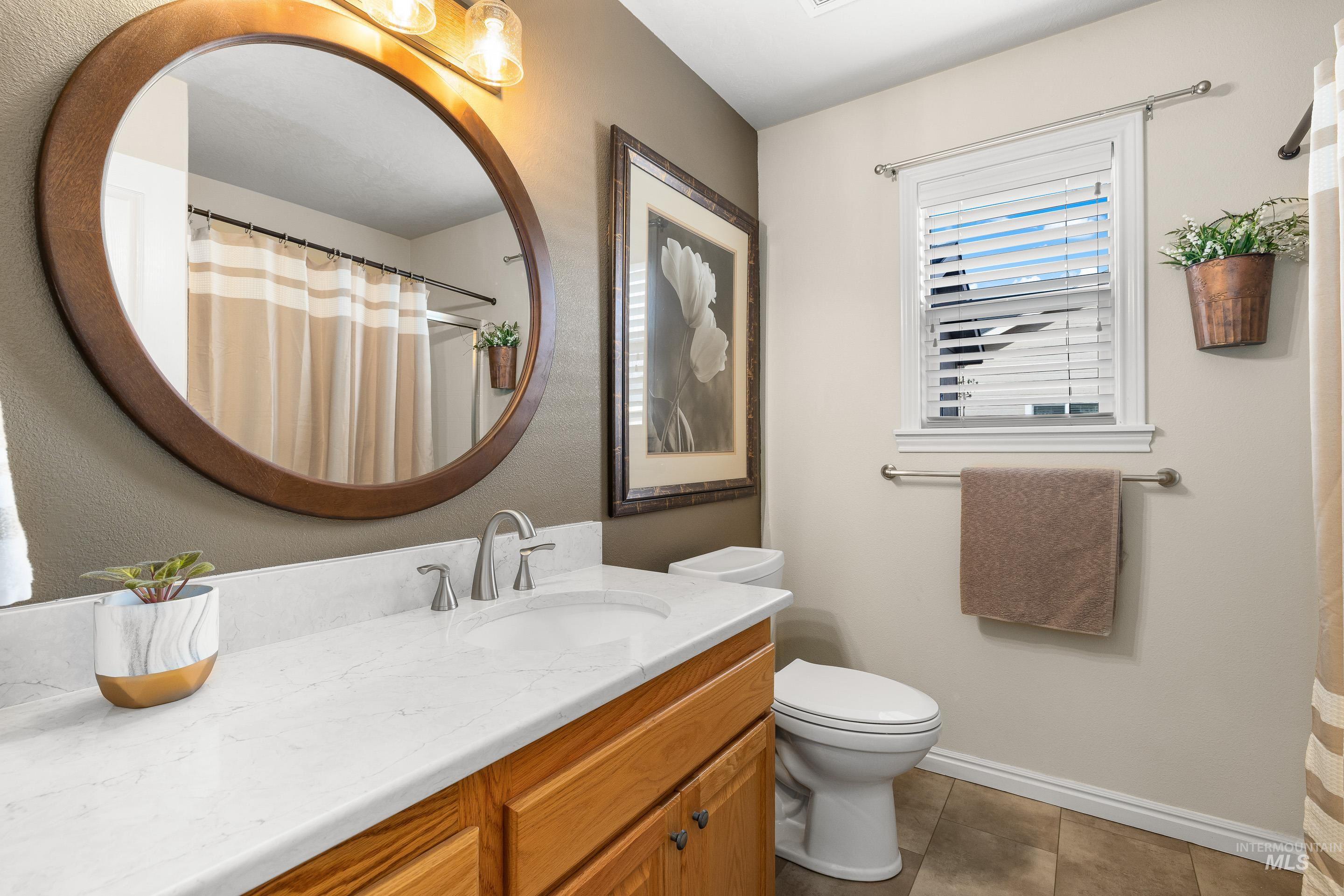 3631 North Alexis Way Meridian, ID 83646 - Photo 37 of 49 Bathroom with curtained shower, vanity, and light tile patterned floors