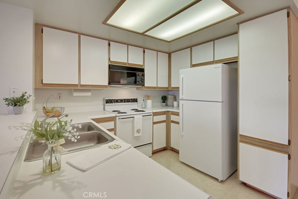 2800 Keller Drive, Unit 282 Tustin, CA 92782 - Photo 4 of 19 a kitchen with appliances a sink and cabinets