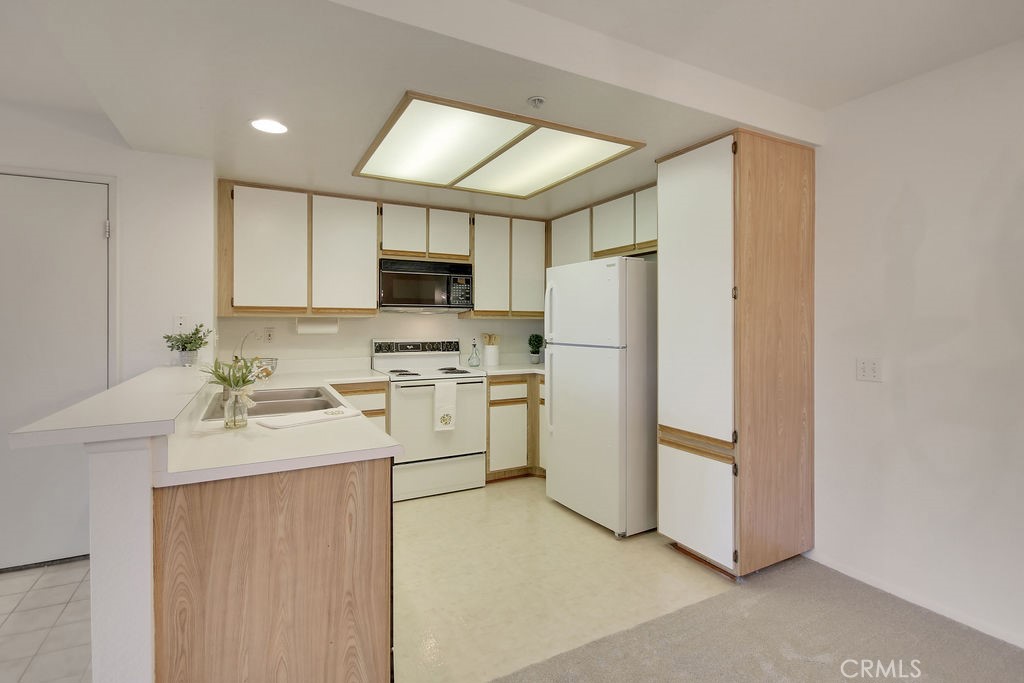 2800 Keller Drive, Unit 282 Tustin, CA 92782 - Photo 5 of 19 a kitchen with a refrigerator sink stove and microwave