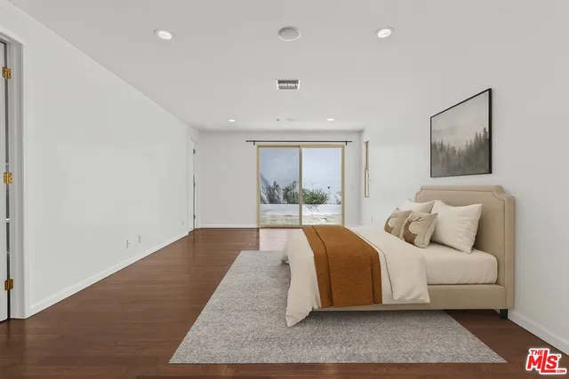 a spacious bedroom with a large bed and a large window