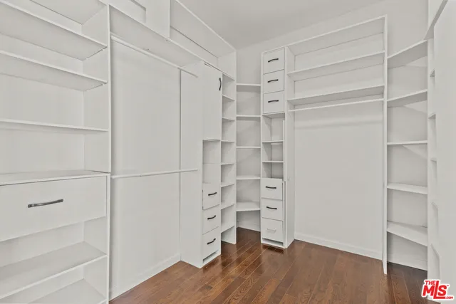 a view of walk in closet with empty racks
