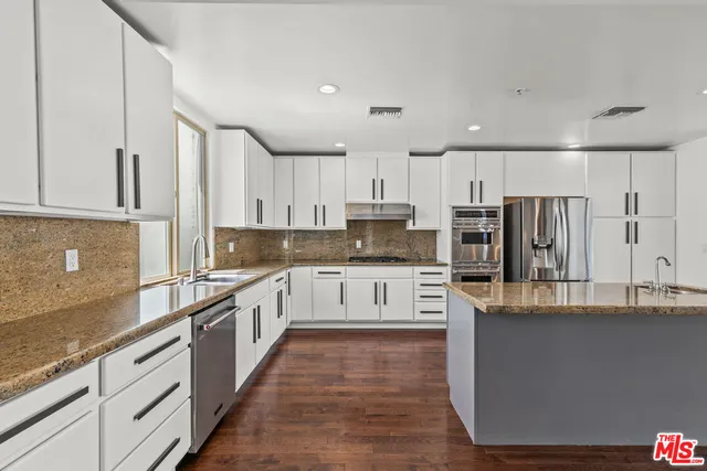 a large kitchen with cabinets and wooden floor