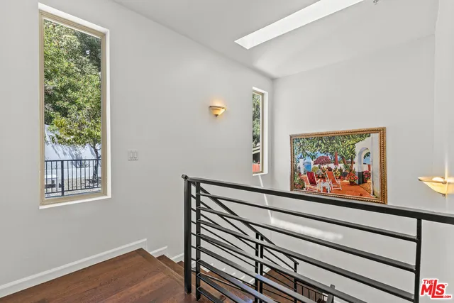 a view of a hallway with wooden floor and a window