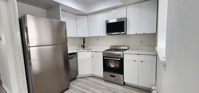 a kitchen with stainless steel appliances a refrigerator stove and microwave