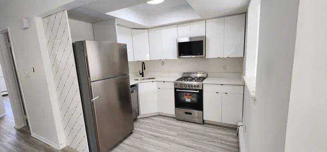 a kitchen with stainless steel appliances a refrigerator a microwave and sink