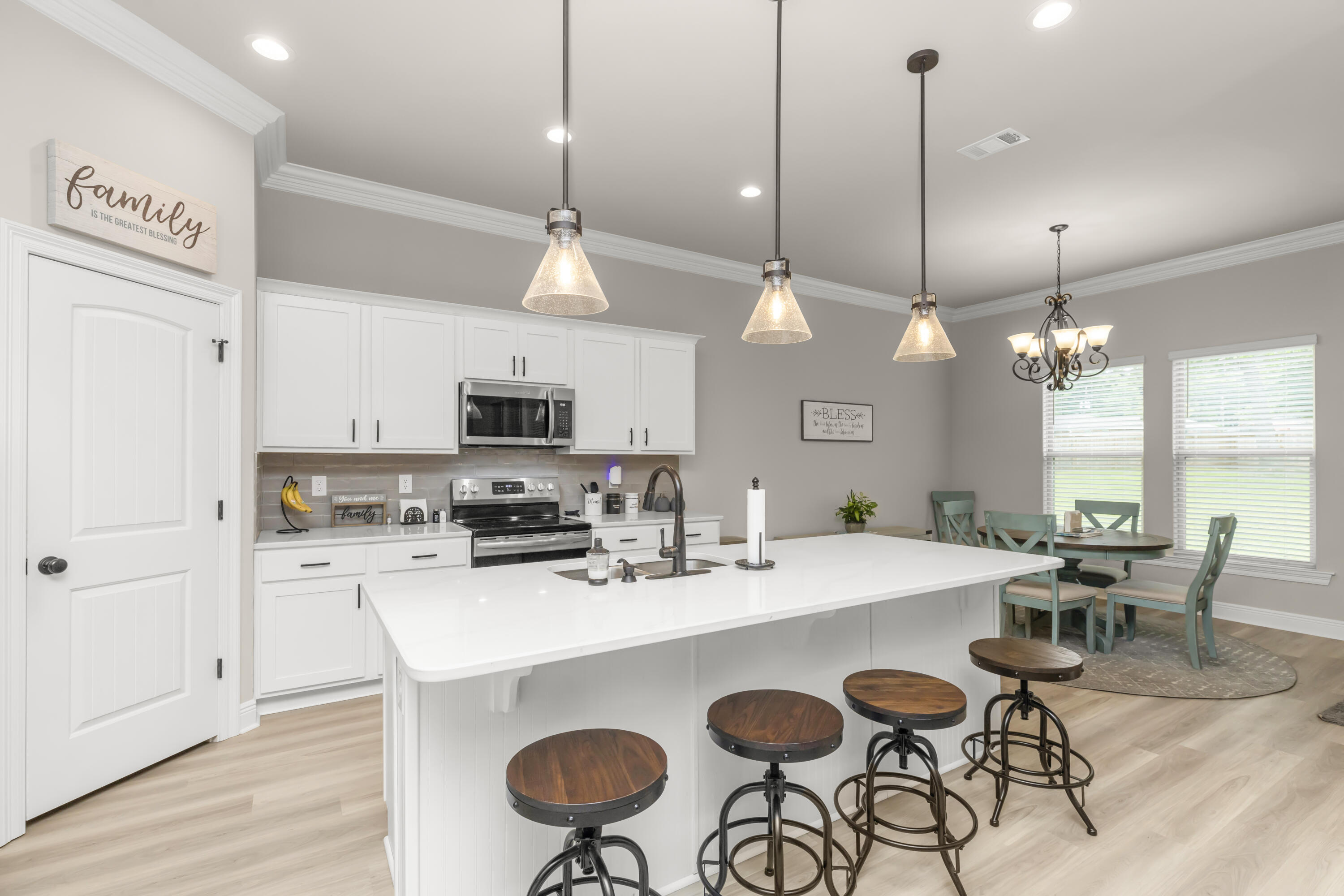 4729 Sago Palm Circle Pace, FL 32571 - Photo 8 of 29 a kitchen with stainless steel appliances a table chairs and white cabinets