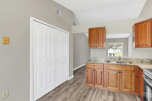 a kitchen with a sink cabinets and wooden floor