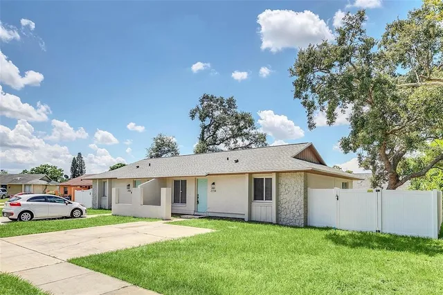 a front view of a house with a garden and yard