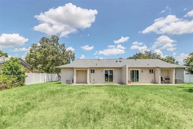 a view of a house with a yard and potted plants