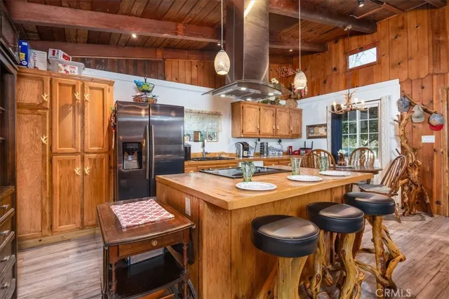 a kitchen with stainless steel appliances granite countertop a dining table and chairs