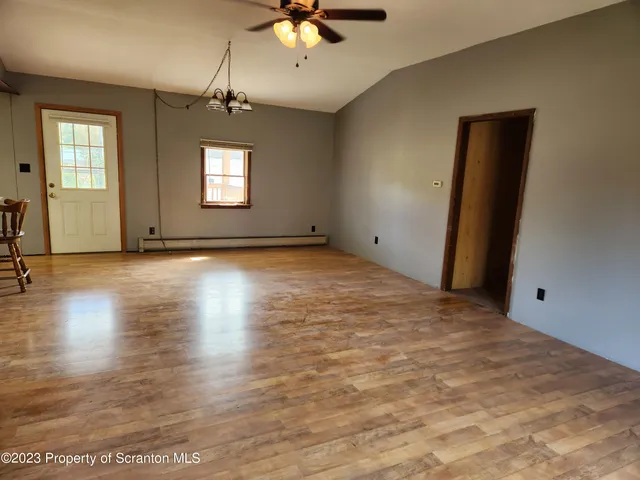 an empty room with fan and windows