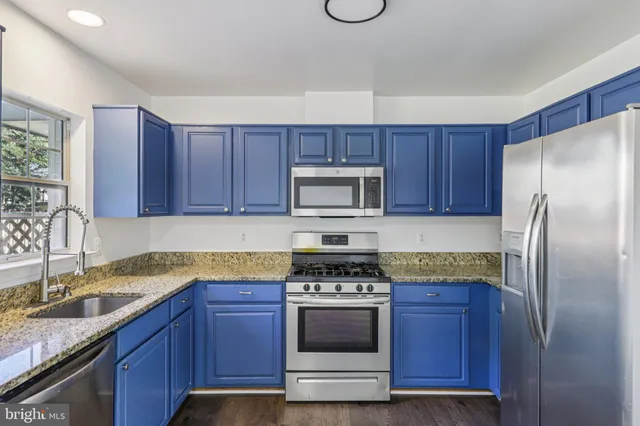 a kitchen with granite countertop wooden cabinets and stainless steel appliances