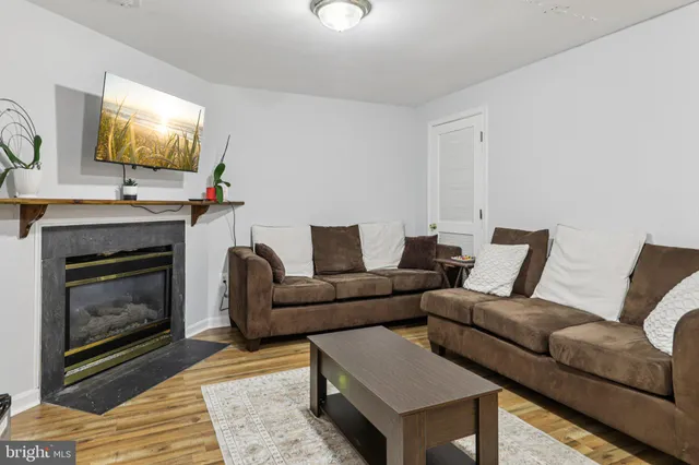 a living room with furniture a flat screen tv and a fireplace