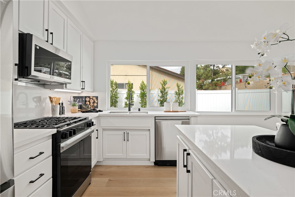 2108 Ardenwood Avenue Simi Valley, CA 93063 - Photo 14 of 33 a kitchen with cabinets appliances a sink and a window