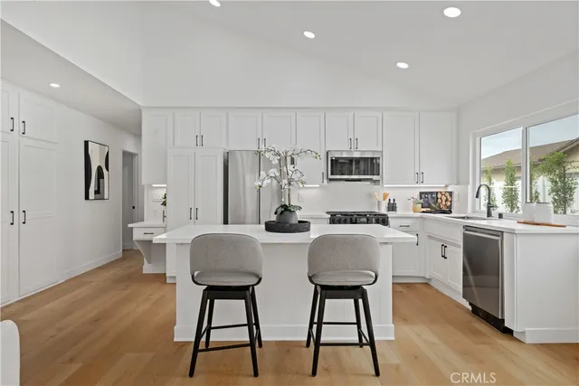 a kitchen with stainless steel appliances granite countertop a white cabinets and wooden floor