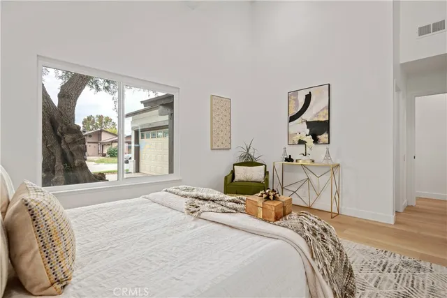 a bedroom with a bed and wooden floor