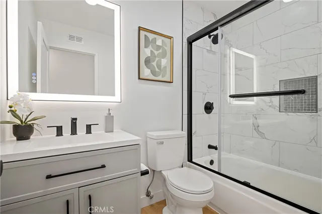 a bathroom with a sink a toilet and a large mirror