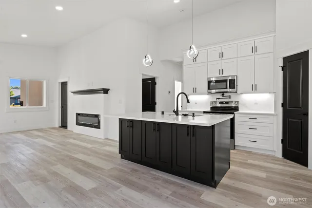 a kitchen with white cabinets and appliances