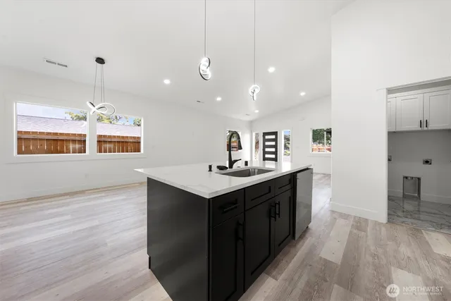 a large kitchen with stainless steel appliances a sink a stove and a refrigerator