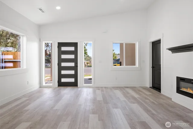 a view of empty room with wooden floor and window