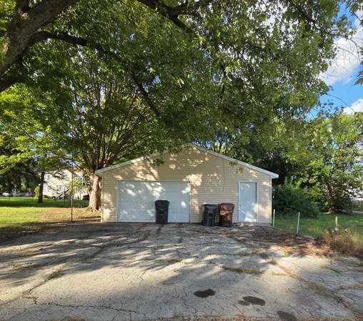 a view of a house with a yard and large tree