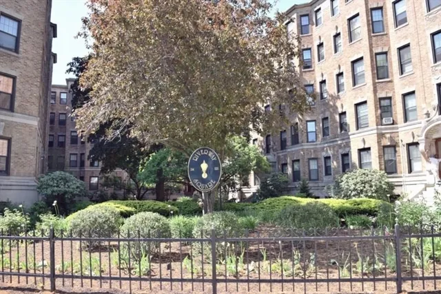 a view of a brick building with a yard and plants