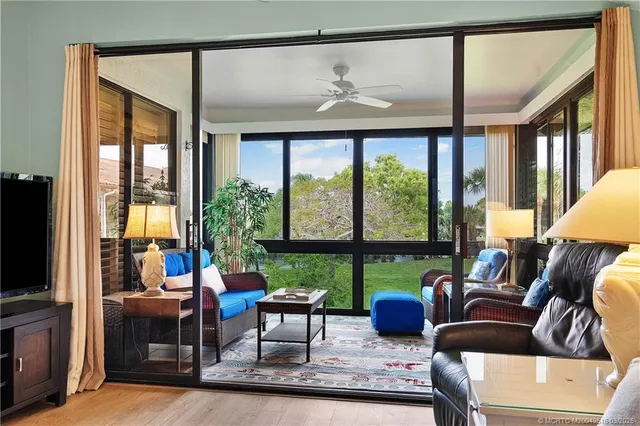a living room with furniture and a floor to ceiling window