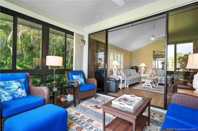 a living room with furniture and a floor to ceiling window