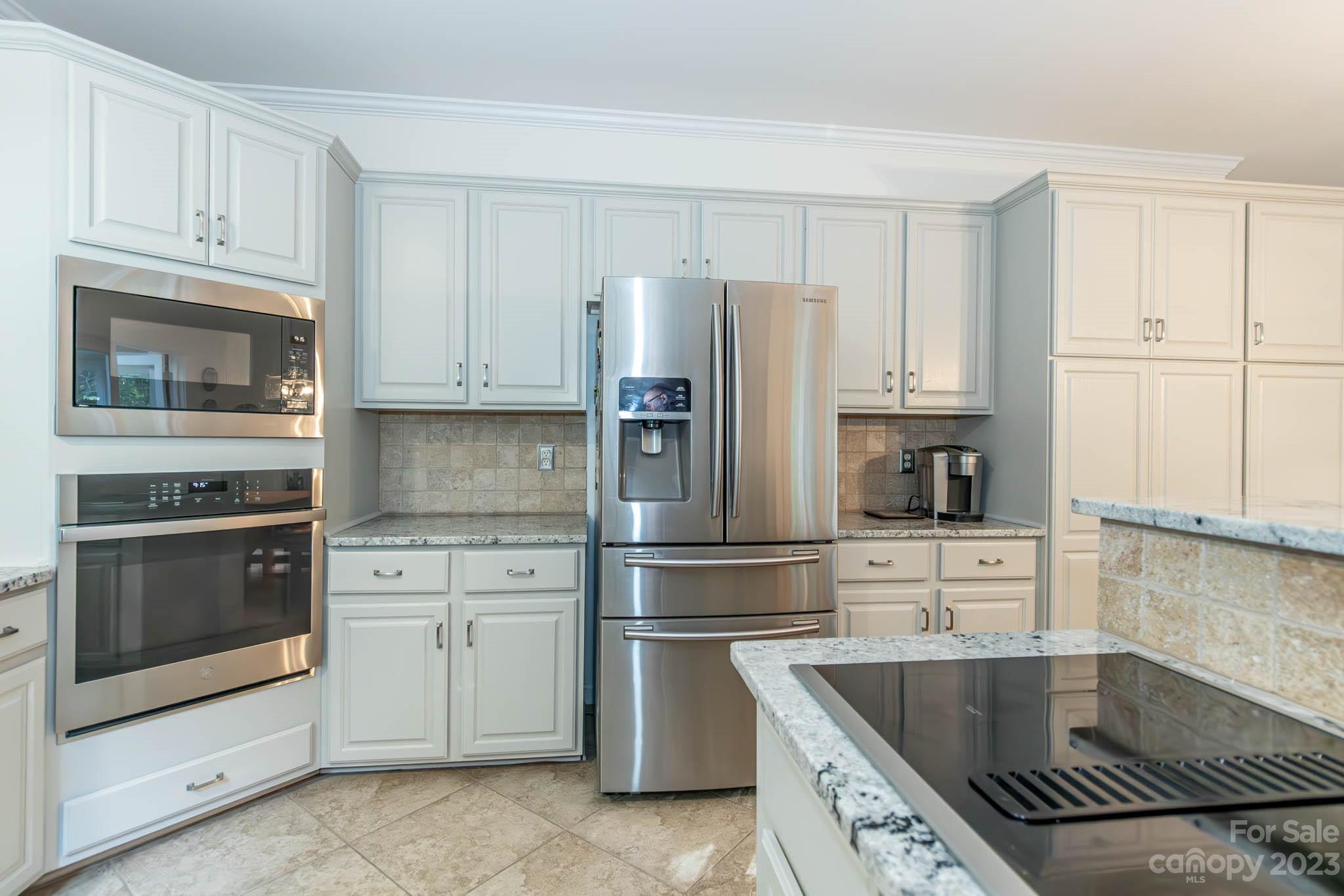 10507 Rougemont Lane Charlotte, NC 28277 - Photo 25 of 48 a kitchen with granite countertop a refrigerator stove and microwave