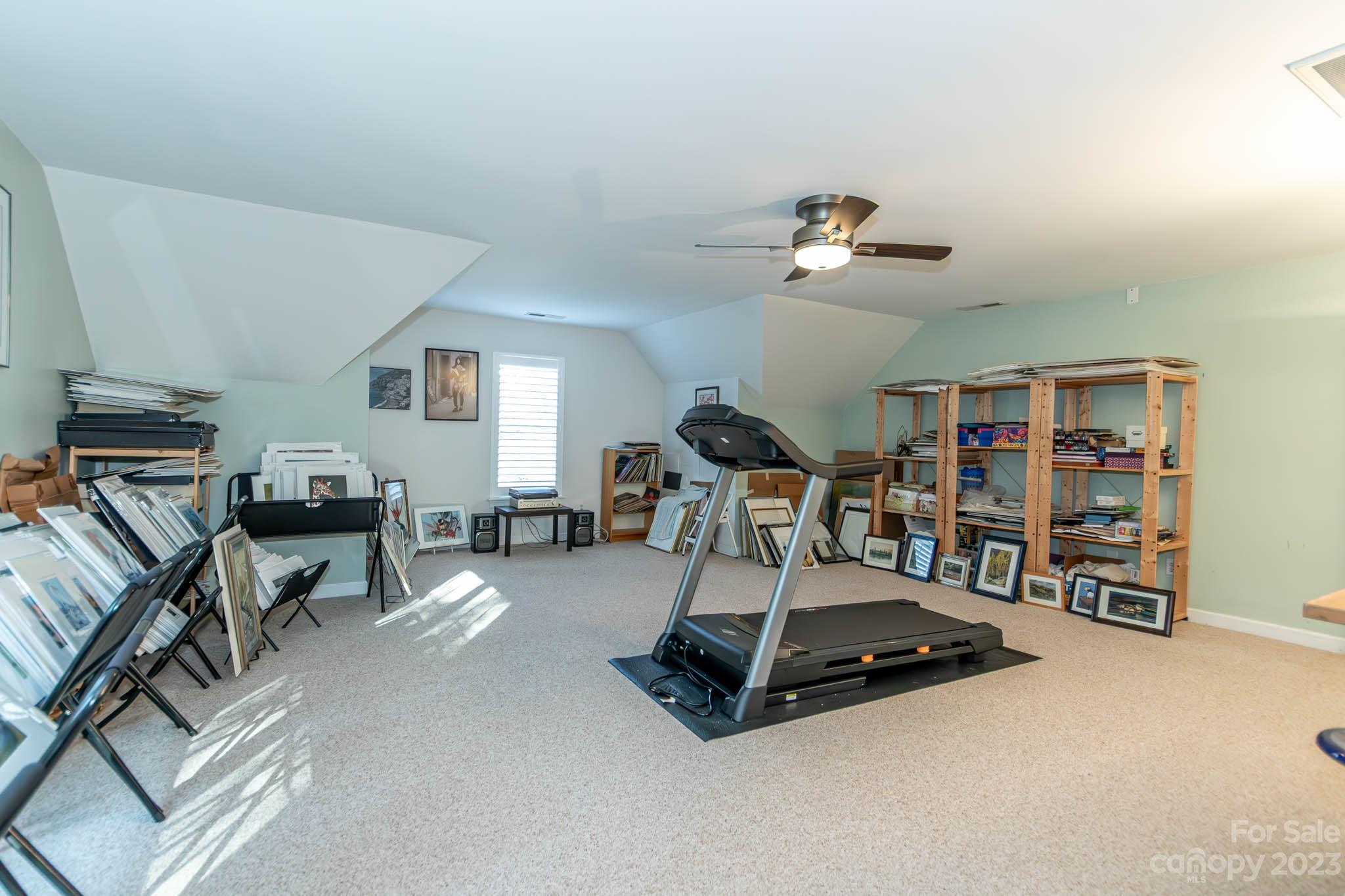 10507 Rougemont Lane Charlotte, NC 28277 - Photo 43 of 48 a living room with furniture gym equipment and a book shelf