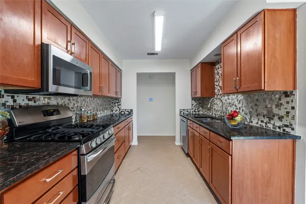 a kitchen with stainless steel appliances granite countertop a stove and a sink