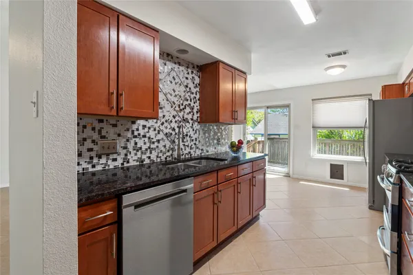 a kitchen with stainless steel appliances granite countertop a sink stove and refrigerator