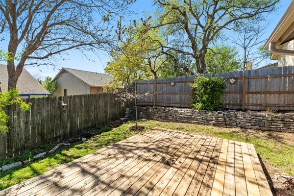 a view of backyard with wooden fence and large trees