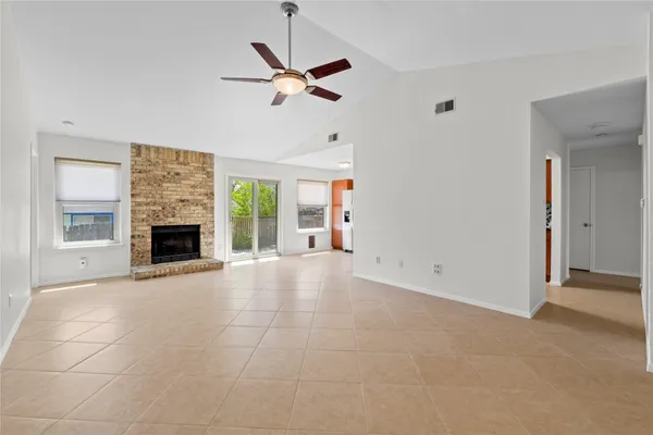a view of an empty room with a fireplace and a window