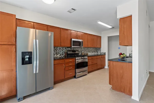 a kitchen with stainless steel appliances granite countertop a refrigerator stove and oven