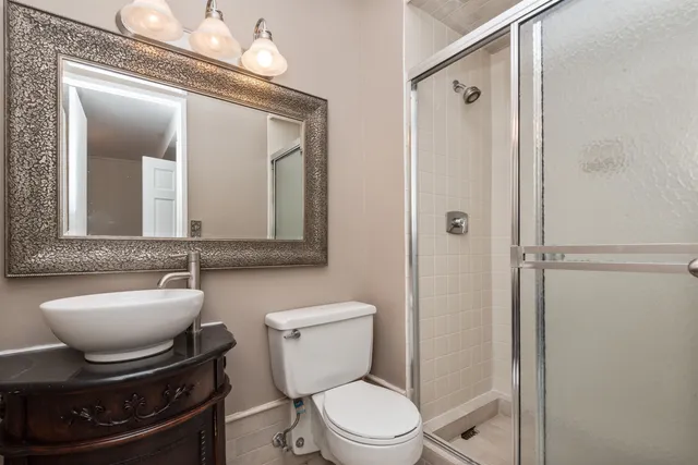 a bathroom with a toilet a sink and mirror