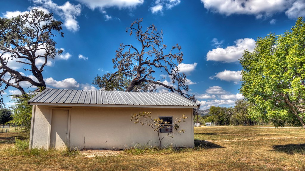 4573 Ranch Road 1120 Rio Frio, TX 78879 - Photo 59 of 71 a backyard of a house with table and chairs under an umbrella
