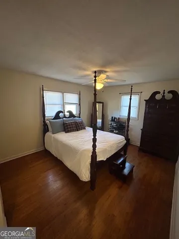 a bedroom with a bed a mirror and dresser