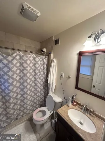 a bathroom with a sink toilet and mirror