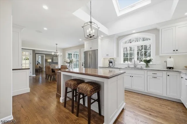 a kitchen with stainless steel appliances granite countertop a stove a sink dishwasher a dining table and chairs with wooden floor