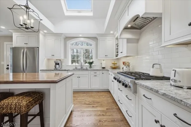 a kitchen with granite countertop stainless steel appliances a sink and cabinets