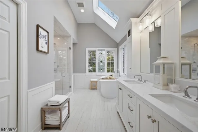 a bathroom with a double vanity sink toilet mirror and bathtub